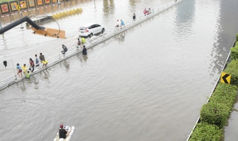 Sejumlah bocah bermain saat banjir yang merendam Jalan Letjen S Parman dan tol dalam kota di Jakarta Barat, Rabu (1/1/2020).