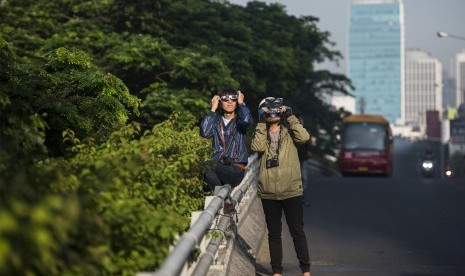 Warga mengamati fase gerhana matahari di kawasan Patung Dirgantara, Pancoran, Jakarta Selatan, Rabu (9/3).