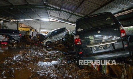 Warga mengamati kendaraan yang terseret banjir bandang di Cicaheum, Bandung, Jawa Barat, Selasa (20/3). 