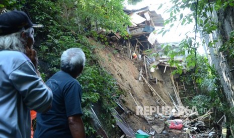 Warga mengamati longsor disebuah tebing sepadan sungai yang terjadi di RT 5 RW 8 Kelurahan Hegarmanah, Kecamatan Cidadap, Kota Bandung, Ahad (19/5). 