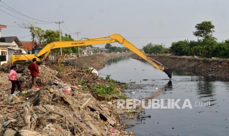 Warga mengamati pengerukan endapan lumpur di Kali Blencong, Kabupaten Bekasi, Jawa Barat, Rabu (8/9/2021). Pengerukan untuk normalisasi Kali Blencong di Kampung Pasir Batu hingga Muara Laut Desa Segara Makmur tersebut guna menanggulangi banjir. 