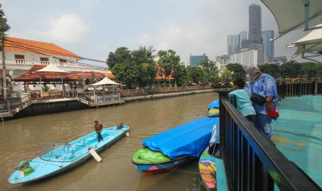 Warga mengamati perahu wisata yang melintas di Sungai Kalimas di Taman Prestasi Jalan Ketabang Kali, Surabaya, Jawa Timur, Sabtu (10/4/2021). Pemkot Surabaya membuka kembali delapan taman kota di Surabaya yang sebelumnya ditutup karena pandemi COVID-19 dengan menerapkan pembatasan jumlah pengunjung dan protokol kesehatan ketat.