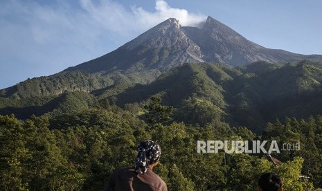 Warga mengamati puncak Gunung Merapi di pos pemantauan kawasan Bukit Klangon, Cangkringan, Sleman, DI Yogyakarta, Sabtu (12/5).