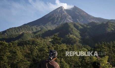 Warga mengamati puncak Gunung Merapi di pos pemantauan kawasan Bukit Klangon, Cangkringan, Sleman, DI Yogyakarta