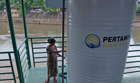 Warga mengambil air untuk diminum dari faslitas filter air bersih di Sungai Ciliwung kawasan Bidara Cina, Jakarta, Selasa (12/1).