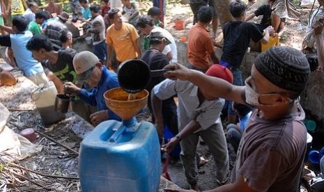 Warga mengambil bahan bakar minyak (BBM) di sekitar jalur pipa milik Pertamina yang bocor di Desa Pasir Batang, Manonjaya, Tasikmalaya, Jawa Barat, (30/7/2013), sebelum akhirnya dilarang oleh Polisi.