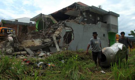 Warga mengambil barang dari sisa reruntuhan bangunan di Mamuju Sulawesi Barat, Jumat (29/1/2021). Memasuki dua pekan pascagempa bumi BNPB merilis jumlah kerusakan rumah sebanyak 7.863 unit, Mamuju 3.741 dan Majene 4.122 unit.