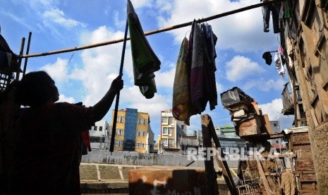 Warga mengangkat jemuran di pemukiman bantaran kali Ciliwung, Bukit Duri, Jakarta Selatan, Kamis (14/7).Republika/Tahta Aidilla