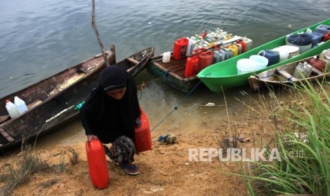 Warga mengangkat jerigen berisi air bersih yang berasal dari air pegunungan di Kelurahan Lapulu, Kendari, Sulawesi Tenggara, Rabu (21/12). Warga Kelurahan Lapulu mengandalkan air pegunungan yang dekat dengan permukiman warga sebagai sumber kebutuhan air be