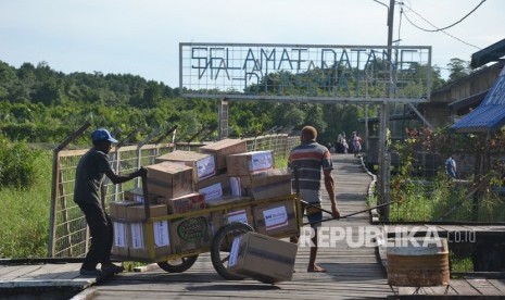 Warga mengangkut bantuan dari Bandara Ewer, Kabupaten Asmat guna disalurkan ke warga terdampak kekurangan gizi dan wabah campak, Kamis (25/1).