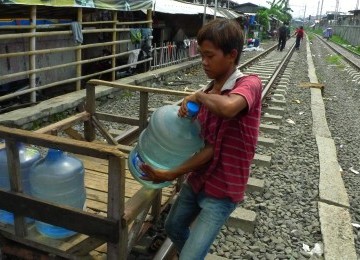 Warga mengangkut galon berisi air bersih untuk dijual di Kampung Bandan, Jakarta Utara, Senin (20/2). (Republika/Aditya Pradana Putra)