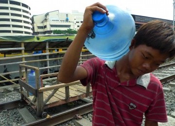 Warga mengangkut galon berisi air bersih untuk dijual di Kampung Bandan, Jakarta Utara, Senin (20/2). (Republika/Aditya Pradana Putra)