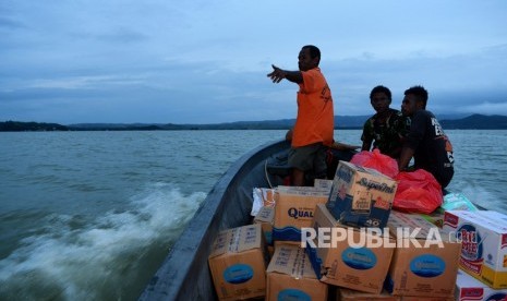 Warga mengantarkan bantuan mengggunakan perahu ke tempat pengungsian di sekitar Danau Sentani di Kampung Yamin di Sentani, Jaya Pura, Papua, Rabu (20/3/2019).