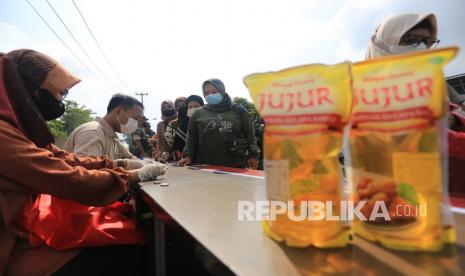 Warga mengantre untuk beli minyak goreng saat operasi pasar di Pasar Karangampel, Indramayu, Jawa Barat, Kamis (17/2/2022). Pemda setempat bekerja sama dengan Perum Bulog menggelar operasi pasar minyak goreng dengan harga Rp14 ribu per liter untuk memenuhi kebutuhan masyarakat.