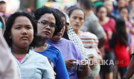 Warga mengantre untuk membeli daging dengan Kartu Jakarta Pintar (KJP) di Kantor Kecamatan Ciracas, Jakarta Timur, Senin (27/6).  (Republika/Rakhmawaty La'lang)