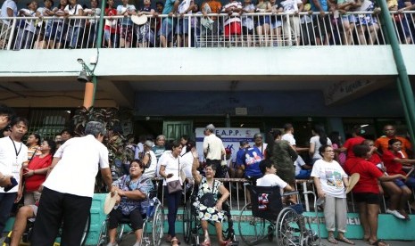 Warga mengantre untuk memberikan suara di tempat pemungutan suara di sekolah dasar Manuel L. Quezon di Manila, Filipina, Senin (13/5). Filipina menggelar pemilu paruh waktu hari ini.