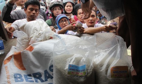 Warga mengantre untuk mendapatkan beras murah dari petugas Bulog Divre DKI Kelapa Gading, dalam operasi pasar beras di Pasar Jatinegara Jakarta Timur, Rabu (25/2). Pemerintah telah menyalurkan beras cadangan sebesar 25.000 ton beras untuk masyarakat miskin