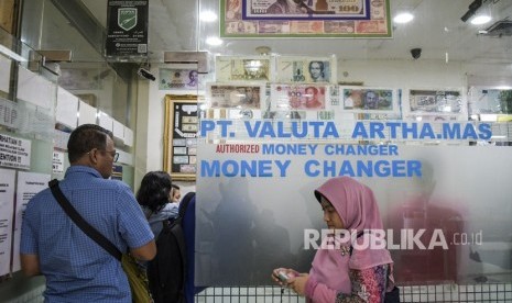 Warga mengantre untuk menukarkan mata uang asing di sebuah money changer (Ilustrasi).