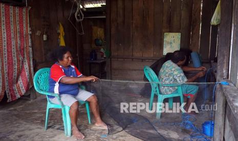 Warga menganyam jaring ikan di Kampung Atkari, Distrik Misol Utara, Kabupaten Raja Ampat, Kamis (4/2/2021). Warga yang tinggal di daerah Terpencil, Terdepan dan Terluar (3T) melakukan berbagai aktivitas keseharian guna menyambung hidup dengan fasilitas kelistrikan yang belum memadai, dari data Bappenas setidaknya 102 Kampung di Papua Barat belum dialiri listrik. 