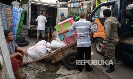 Warga mengemasi barang-barang di kawasan Bukit Duri, Jakarta Selatan, Ahad (14/8). (Republika/Yasin Habibi)