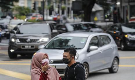 Warga mengenakan masker di Kuala Lumpur, Malaysia. Hingga Sabtu (18/12), Malaysia sudah memiliki total 12 kasus positif Omicron.