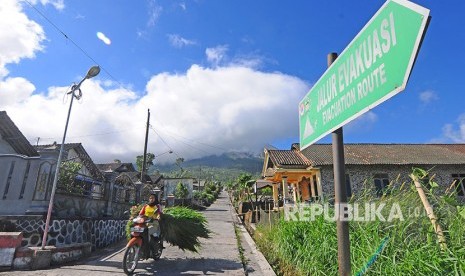 Warga mengendarai motor di jalan pedesaan lereng Gunung Merapi.