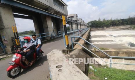 Warga mengendarai sepeda motor di kawasan bendungan Waru Turi, Kediri, Jawa Timur, Rabu (2/3/2022). Kawasan wisata sekaligus akses penyeberangan sungai Brantas Kediri-Nganjuk tersebut kembali dibuka untuk umum setelah sebelumnya ditutup guna mengantisipasi penularan COVID-19. 