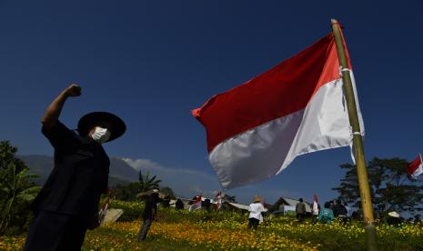 Warga mengepalkan tangan ketika mengikuti upacara peringatan HUT Kemerdekaan ke-76 Republik Indonesia di Taman Refugia, Desa Penanggungan, Trawas, Kabupataen Mojokerto, Jawa Timur, Selasa (17/8/2021). Selain meningkatkan semangat rasa cinta tanah air, upacara detik-detik Proklamasi Kemerdekaan Indonesia tersebut juga bertujuan memperkenalkan wisata pertanian kepada masyarakat.