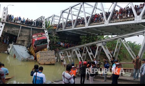 Warga mengerumuni lokasi jembatan Widang yang runtuh, Tuban, Jawa Timur, Selasa (17/4). Sisi barat jembatan itu runtuh sekitar 50 meter dan mengakibatkan satu pengemudi truk meninggal dunia, dan melukai tiga korban lainnya, sementara tiga truk dan sebuah sepeda motor masuk ke Bengawan Solo. 