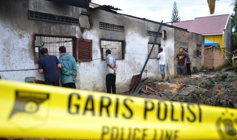 Warga mengerumuni lokasi rumah yang dijadikan pabrik pembuat korek gas (mancis) pasca kebakaran di Desa Sambirejo, Kecamatan Binjai, Kabupaten Langkat, Sumatra Utara, Sabtu (22/6). Peristiwa kebakaran menewaskan 30 orang.