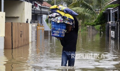 Warga mengevakuasi barang-barang dari rumahnya yang terendam banjir di Bandar Lampung, Lampung, Ahad (19/1). 