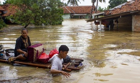 Warga mengevakuasi keluarganya mengunakan perahu rakit saat banjir di Karawang, Jawa Barat (ilustrasi)