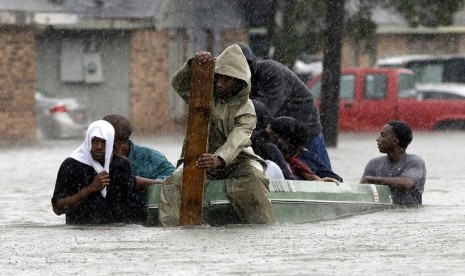 Warga mengevakuasi tetangga mereka yang terkena banjir di LaPlace,Los Angeles,Kamis (30/8) waktu setempat.    (Eric Gay/AP)