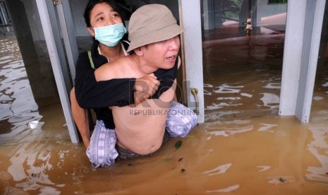   Warga mengevakuasi warga lainnya dari perkampungan yang terendam banjir luapan Sungai Ciliwung di Kebon Baru, Tebet, Jakarta Selatan, Rabu (16/1).  (Republika/Aditya Pradana Putra)