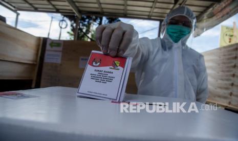 Warga menggunakan Alat Pelindung Diri (APD) kesehatan saat menggunakan hak pilihnya pada Pilkada Kabupaten Bandung di TPS 10, Desa Pangauban, Kabupaten Bandung, Jawa Barat, Rabu (9/12/2020). DPR saat ini tengah membahas revisi UU Pemilu. (ilustrasi)