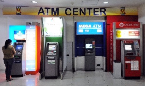 Warga menggunakan ATM di Jakarta. Otoritas Jasa Keuangan (OJK) akan mengeluarkan tiga peraturan baru untuk perbankan.