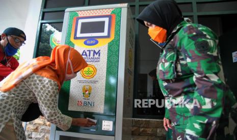 Warga menggunakan ATM Pertanian Sikomandan untuk mendapatkan beras gratis.