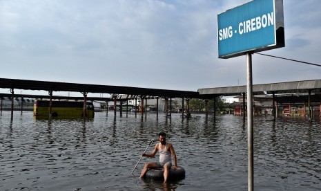 Warga menggunakan ban bekas untuk melintasi banjir rob yang merendam Terminal Bus Terboyo di Semarang, Jawa Tengah, Jumat (2/6). 