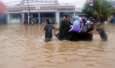   Warga menggunakan gerobak untuk evakuasi saat banjir melanda di Kebon Baru, Tebet, Jakarta Selatan, Rabu (16/1). (Republika/Aditya Pradana Putra)