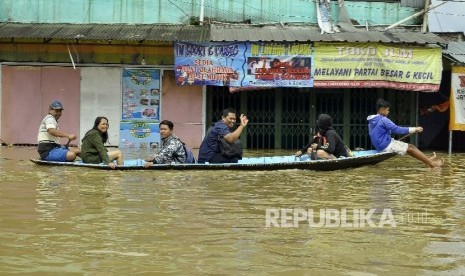  Warga menggunakan jasa perahu kayu untuk menerobos banjir yang merendam di Jalan Raya Banjaran di Kelurahan Andir, Kecamatan Baleendah, Kabupaten Bandung, Rabu (8/3).