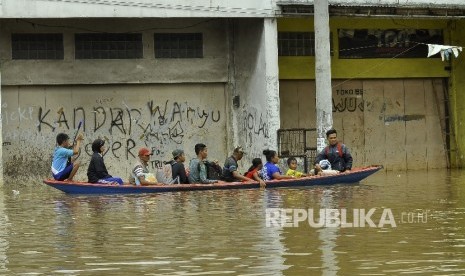 Warga menggunakan jasa perahu kayu untuk menerobos banjir yang merendam di Jalan Raya Banjaran di Kelurahan Andir, Kecamatan Baleendah, Kabupaten Bandung, Rabu (8/3).