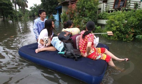 Warga menggunakan kasur karet ketika berusaha keluar dari pemukiman mereka yang terendam banjir di kawasan Periuk, Tangerang, Banten, Selasa (10/2).(ANTARA/Rivan Awal Lingga)