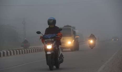  Residents use masks when passing on the road covered in smoke haze in the city of Dumai, Dumai, Riau, Thursday (Aug 16).