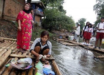 Warga menggunakan MCK darurat di bantaran kali Ciliwung, Bukit Duri, Jakarta, Senin (19/3). (Republika/Adhi Wicaksono)