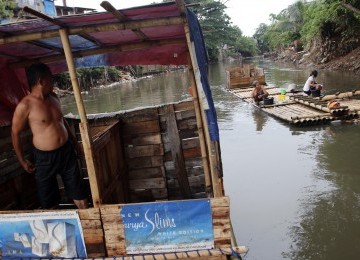 Warga menggunakan MCK darurat di bantaran kali Ciliwung, Bukit Duri, Jakarta, Senin (19/3). (Republika/Adhi Wicaksono)