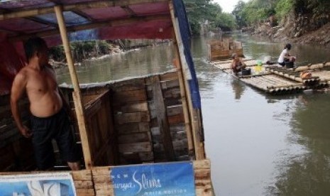 Warga menggunakan MCK darurat di bantaran kali Ciliwung, Bukit Duri, Jakarta, Senin (19/3). (Republika/Adhi Wicaksono)