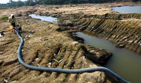 Warga menggunakan mesin diesel untuk menyedot air dari sisa aliran air Sungai Cisadane di sekitar Pintu Air 10, Tangerang, Banten, Selasa (18/8). 