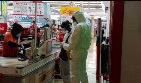 Warga tampak menggunakan baju hazmat sedang berbelanja di salah satu swalayan mal di Jakarta Selatan. 