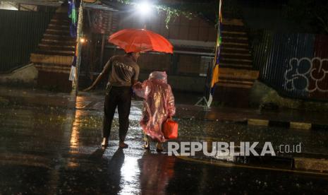 Warga menggunakan payung berjalan menerjang hujan lebat di Sidoarjo, Jawa Timur, Sabtu (11/9/2021). Badan Meteorologi, Klimatologi, dan Geofisika (BMKG) mengeluarkan peringatan dini prakiraan hujan lebat disertai kilat dan angin kencang yang berpotensi terjadi di beberapa wilayah Indonesia, termasuk Jawa Timur. 