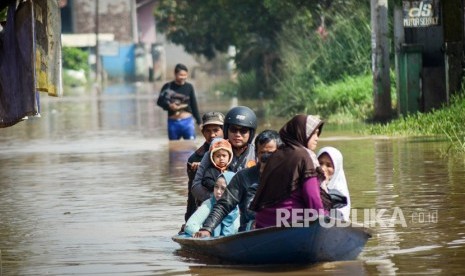 Warga menggunakan perahu kayu melintasi banjir di Dayeuhkolot, Kabupaten Bandung, Jawa Barat (ilustrasi)